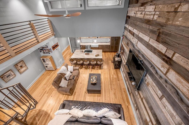 517 W Main St, Lexington, KY 40507 - living area featuring wood finished floors, wooden walls, a ceiling fan, baseboards, and a fireplace