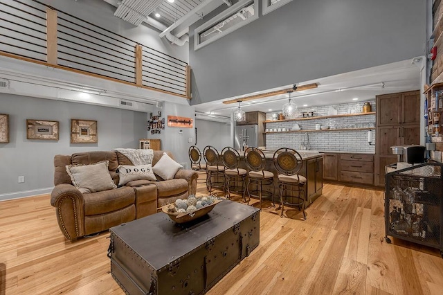 517 W Main St, Lexington, KY 40507 - living area with a high ceiling, light wood-style floors, bar area, and baseboards