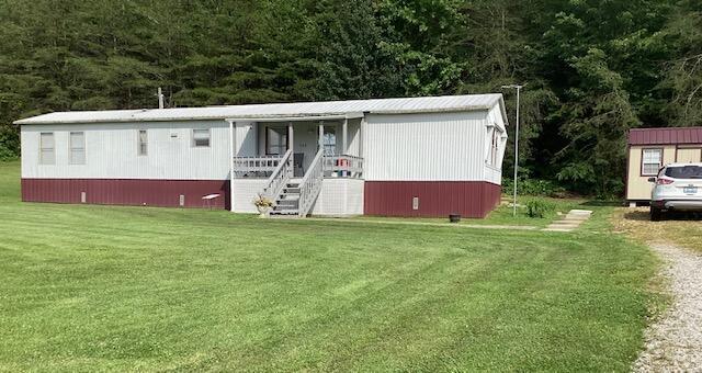 700 Rube Brown Rd, Hustonville, KY 40437 - manufactured / mobile home featuring a front lawn, stairs, and a wooded view
