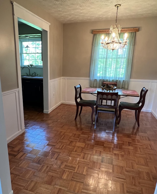 155 Greenfield Subdivision, Corbin, KY 40701 - dining area with a chandelier, a wainscoted wall, a textured ceiling, and a decorative wall