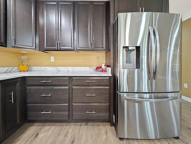 4663 Larkhill Ln, Lexington, KY 40509 - kitchen featuring stainless steel fridge, light wood finished floors, dark brown cabinetry, and light stone countertops