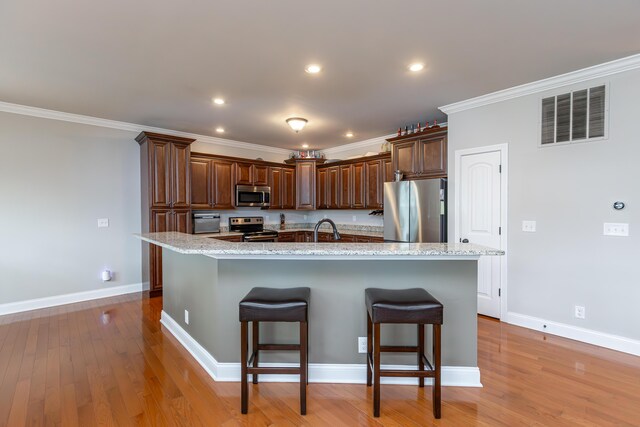 3757 Hardwood Rd, Lexington, KY 40509 - kitchen featuring stainless steel appliances, a kitchen breakfast bar, a sink, light wood finished floors, and light stone countertops