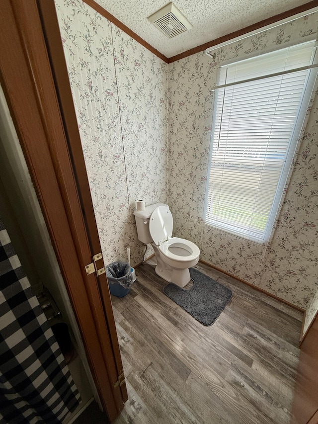 8040 Somerset Rd, London, KY 40741 - bathroom with wood finished floors, toilet, crown molding, wallpapered walls, and a textured ceiling