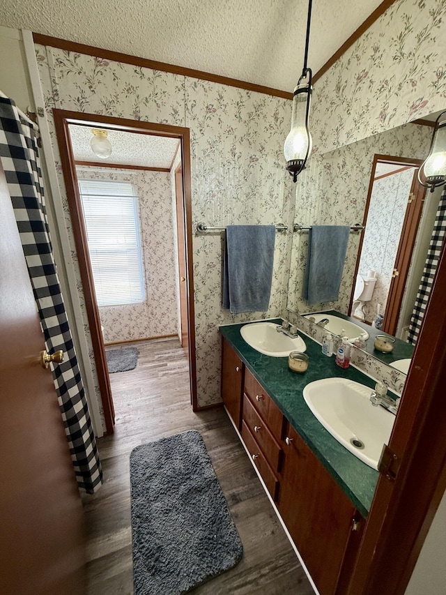 8040 Somerset Rd, London, KY 40741 - full bath featuring wallpapered walls, wood finished floors, crown molding, a textured ceiling, and double vanity