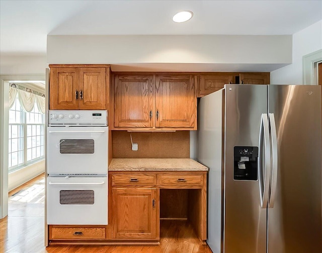 523 Leawood Dr, Frankfort, KY 40601 - kitchen featuring stainless steel fridge, double oven, brown cabinetry, tasteful backsplash, and light wood-style floors