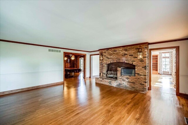 523 Leawood Dr, Frankfort, KY 40601 - unfurnished living room with wood finished floors, ornamental molding, a fireplace, and baseboards