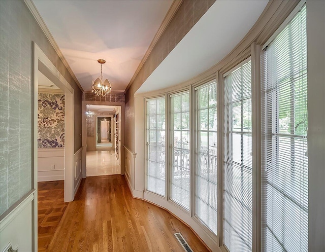 523 Leawood Dr, Frankfort, KY 40601 - hallway with a chandelier, ornamental molding, plenty of natural light, light wood-style floors, and a wainscoted wall