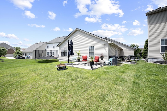 1017 Sugarbush Trl, Lexington, KY 40509 - rear view of house with a trampoline, a patio area, a lawn, and an outdoor fire pit