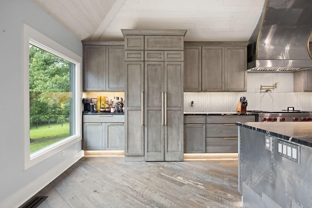 104 Barkley Ests, Nicholasville, KY 40356 - kitchen with wall chimney exhaust hood, light wood finished floors, tasteful backsplash, range, and baseboards