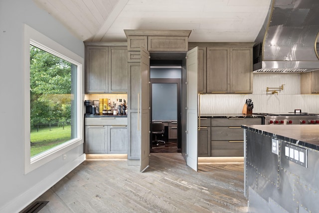 104 Barkley Ests, Nicholasville, KY 40356 - kitchen with wall chimney exhaust hood, light wood finished floors, dark countertops, and tasteful backsplash