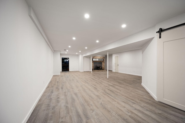 104 Barkley Ests, Nicholasville, KY 40356 - unfurnished living room featuring recessed lighting, wood finished floors, a large fireplace, a barn door, and baseboards