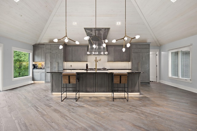 104 Barkley Ests, Nicholasville, KY 40356 - kitchen with wall chimney range hood, baseboards, dark countertops, a large island with sink, and light wood finished floors