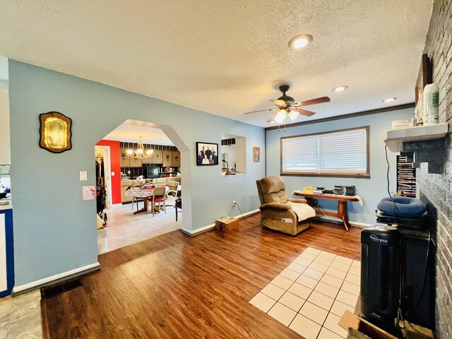 1465 Ky-1629, Corbin, KY 40701 - living area featuring arched walkways, ceiling fan, wood finished floors, a textured ceiling, and a chandelier