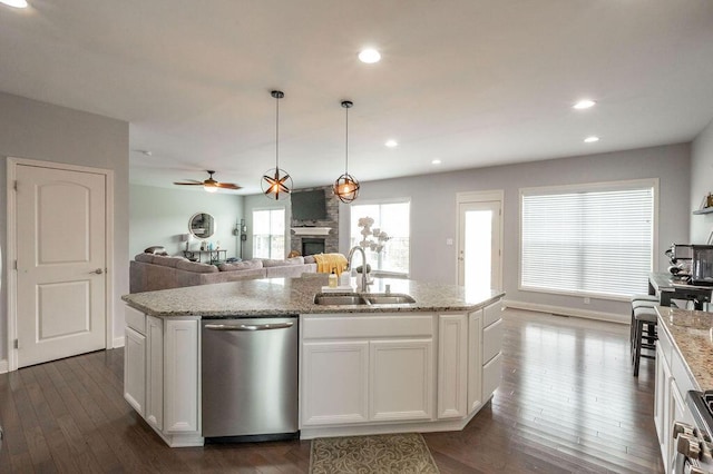177 Swilcan Bridge Way, Georgetown, KY 40324 - kitchen with stainless steel dishwasher, a sink, a large fireplace, an island with sink, and dark wood-type flooring