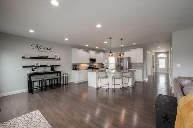 177 Swilcan Bridge Way, Georgetown, KY 40324 - kitchen featuring appliances with stainless steel finishes, a breakfast bar area, a center island, white cabinets, and dark wood-style floors