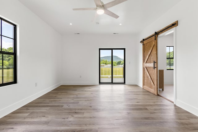 138 Hickory Grove Ln, Stanton, KY 40380 - empty room with a barn door, recessed lighting, a ceiling fan, and light wood-type flooring
