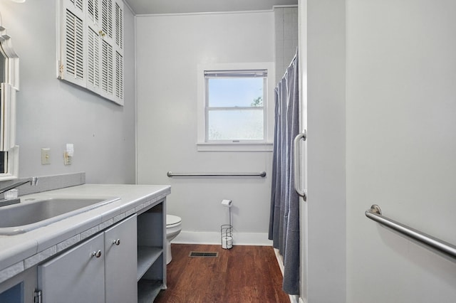 832 N 25th St, Middlesboro, KY 40965 - full bath featuring vanity, toilet, wood finished floors, baseboards, and curtained shower
