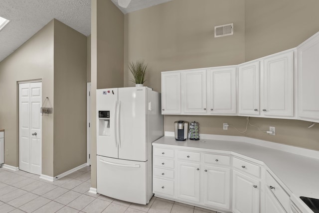 1217 Wyndham Hills Dr, Lexington, KY 40514 - kitchen with white fridge with ice dispenser, white cabinetry, light tile patterned floors, light countertops, and a textured ceiling