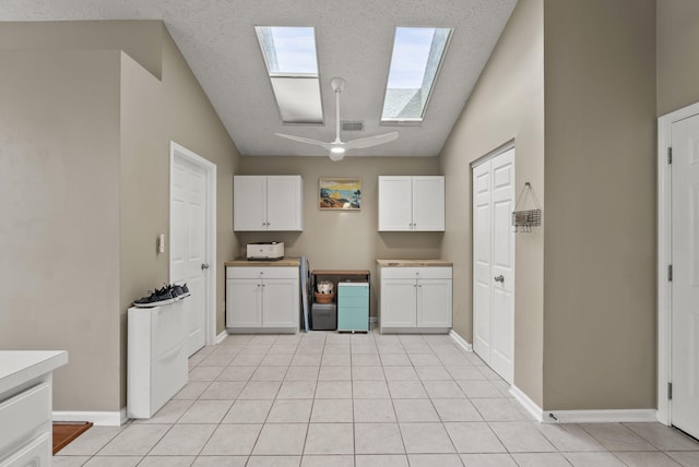 1217 Wyndham Hills Dr, Lexington, KY 40514 - kitchen featuring a skylight, white cabinetry, baseboards, and a ceiling fan