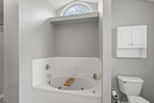 1217 Wyndham Hills Dr, Lexington, KY 40514 - bathroom with a tub with jets, toilet, lofted ceiling, and a textured ceiling
