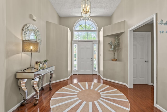 1217 Wyndham Hills Dr, Lexington, KY 40514 - entryway featuring wood finished floors, a textured ceiling, a chandelier, high vaulted ceiling, and baseboards