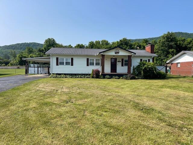 600 S 38th St, Middlesboro, KY 40965 - view of front facade featuring a front lawn, a carport, driveway, and a porch