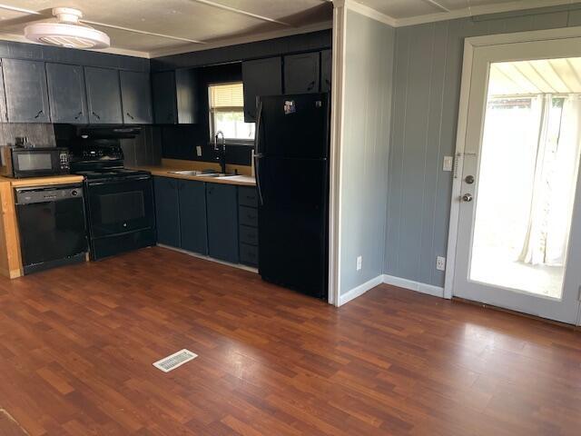 600 S 38th St, Middlesboro, KY 40965 - kitchen with black appliances, a sink, ornamental molding, light countertops, and dark wood finished floors