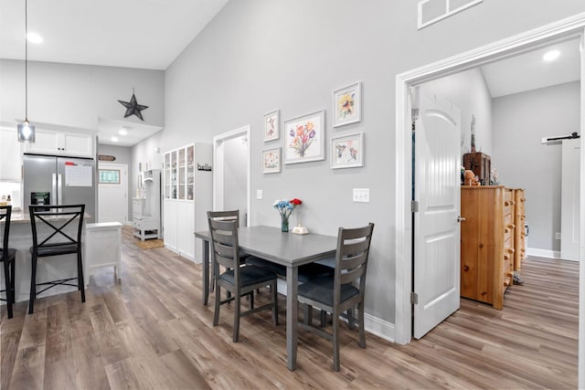 116 Hackberry Ct, Frankfort, KY 40601 - dining room featuring light wood-type flooring, high vaulted ceiling, baseboards, a barn door, and recessed lighting