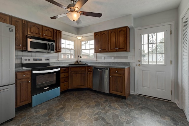 1818 Marlboro Dr, Lexington, KY 40505 - kitchen featuring appliances with stainless steel finishes, a sink, stone flooring, and dark countertops