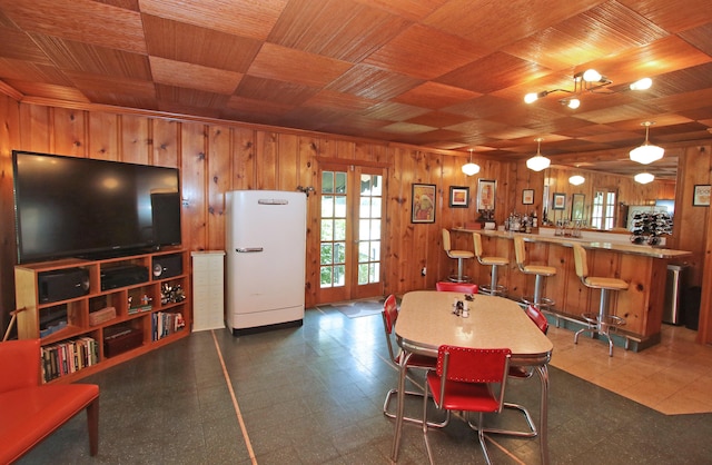 937 Mason Headley Rd, Lexington, KY 40504 - dining space featuring wood walls, dark flooring, wooden ceiling, and bar area