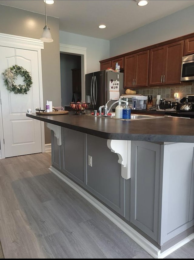 133 W Mcintosh Park, Georgetown, KY 40324 - kitchen with dark countertops, stainless steel appliances, light wood finished floors, tasteful backsplash, and hanging light fixtures