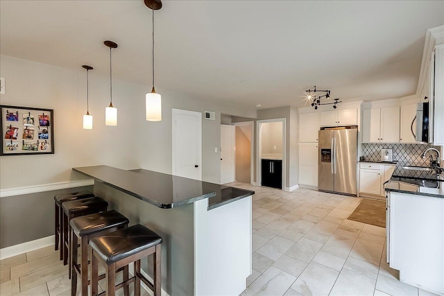 235 Westover Rd, Frankfort, KY 40601 - kitchen featuring appliances with stainless steel finishes, dark countertops, decorative backsplash, a kitchen breakfast bar, and baseboards