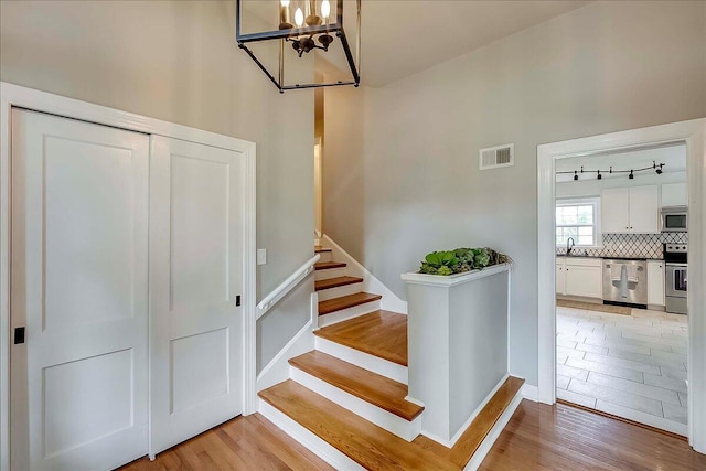 235 Westover Rd, Frankfort, KY 40601 - stairs with wood finished floors, a chandelier, and baseboards