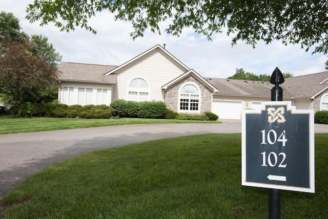 102 Academy Dr, Wilmore, KY 40390 - ranch-style house with driveway, a front yard, an attached garage, and stone siding