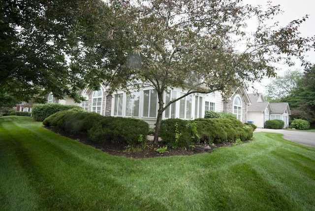 102 Academy Dr, Wilmore, KY 40390 - view of home's exterior featuring a lawn, stone siding, and a garage
