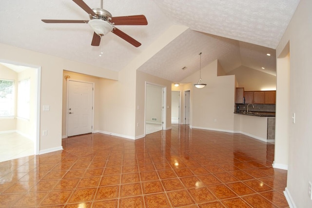 102 Academy Dr, Wilmore, KY 40390 - unfurnished living room with tile patterned flooring, vaulted ceiling, a sink, ceiling fan, and baseboards