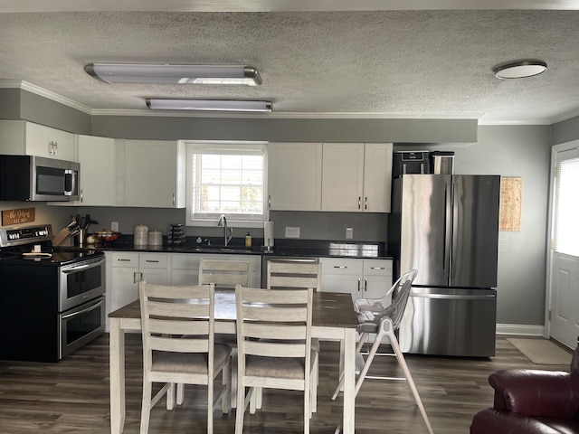 310 Yorktown Dr, Paris, KY 40361 - kitchen featuring stainless steel appliances, a sink, a textured ceiling, dark wood-style flooring, and dark countertops