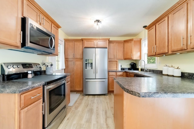 913 W 8th St, Corbin, KY 40701 - kitchen with appliances with stainless steel finishes, a sink, dark countertops, and light wood-style flooring