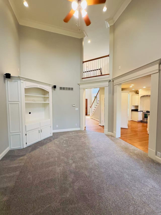 3217 Malone Dr, Lexington, KY 40513 - unfurnished living room with carpet floors, ceiling fan, stairway, ornamental molding, and a towering ceiling