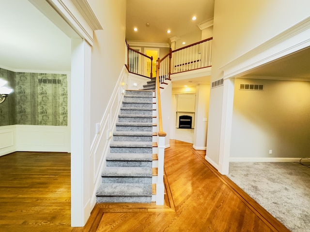 3217 Malone Dr, Lexington, KY 40513 - stairway featuring wood finished floors, crown molding, a wainscoted wall, recessed lighting, and a fireplace