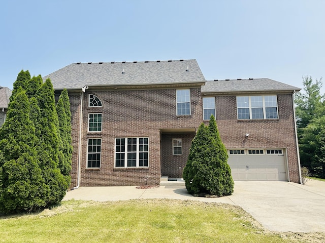 3217 Malone Dr, Lexington, KY 40513 - rear view of house featuring concrete driveway, a garage, brick siding, a yard, and roof with shingles