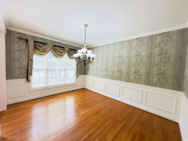 3217 Malone Dr, Lexington, KY 40513 - unfurnished dining area with a chandelier, a wainscoted wall, wood finished floors, crown molding, and a decorative wall