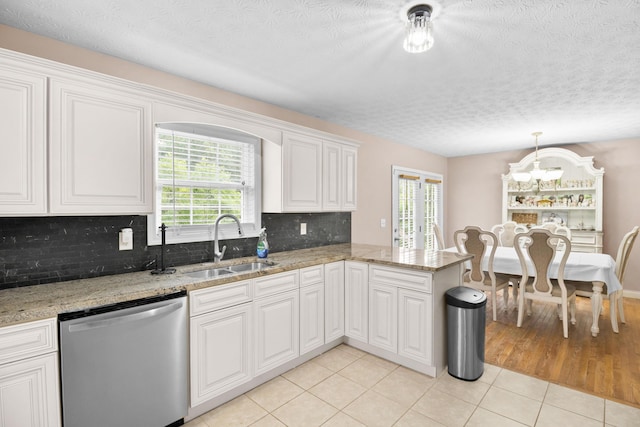 15 April Ln, Corbin, KY 40701 - kitchen with stainless steel dishwasher, a sink, a chandelier, light tile patterned floors, and tasteful backsplash