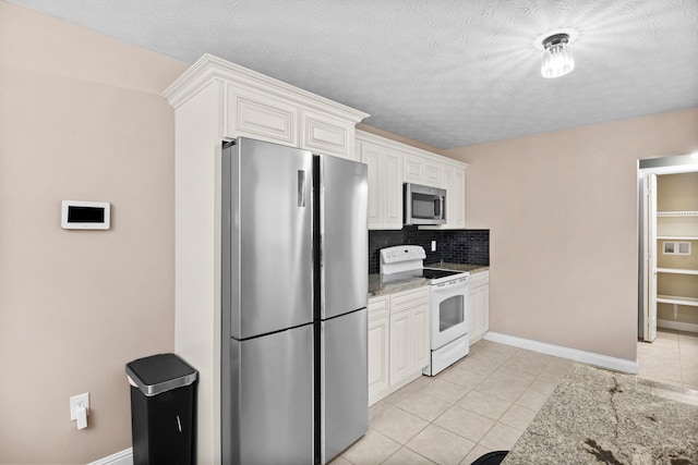 15 April Ln, Corbin, KY 40701 - kitchen with stainless steel appliances, decorative backsplash, light tile patterned flooring, and white cabinets