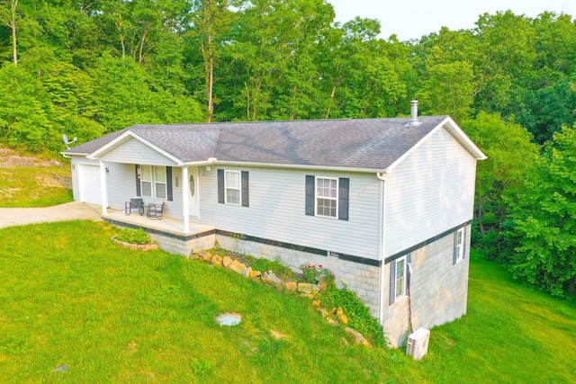15 April Ln, Corbin, KY 40701 - view of front of home with concrete driveway, a porch, a front yard, a garage, and a forest view
