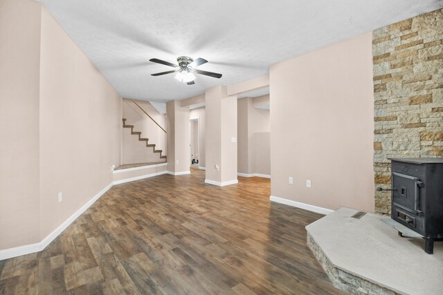 15 April Ln, Corbin, KY 40701 - unfurnished living room with a wood stove, ceiling fan, wood finished floors, baseboards, and a textured ceiling