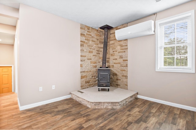 15 April Ln, Corbin, KY 40701 - detailed view of a wall mounted AC, a wood stove, baseboards, and wood finished floors