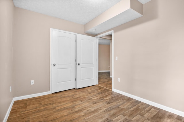 15 April Ln, Corbin, KY 40701 - unfurnished bedroom featuring wood finished floors, baseboards, and a textured ceiling