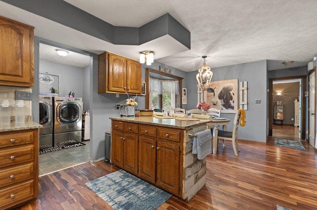 2003 Cresent Cir, Corbin, KY 40701 - kitchen with washer and clothes dryer, brown cabinetry, dark wood-style flooring, a peninsula, and a chandelier