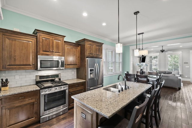 10910 Kings Crown Dr, Prospect, KY 40059 - kitchen with stainless steel appliances, a sink, ornamental molding, dark wood-style flooring, and light stone counters